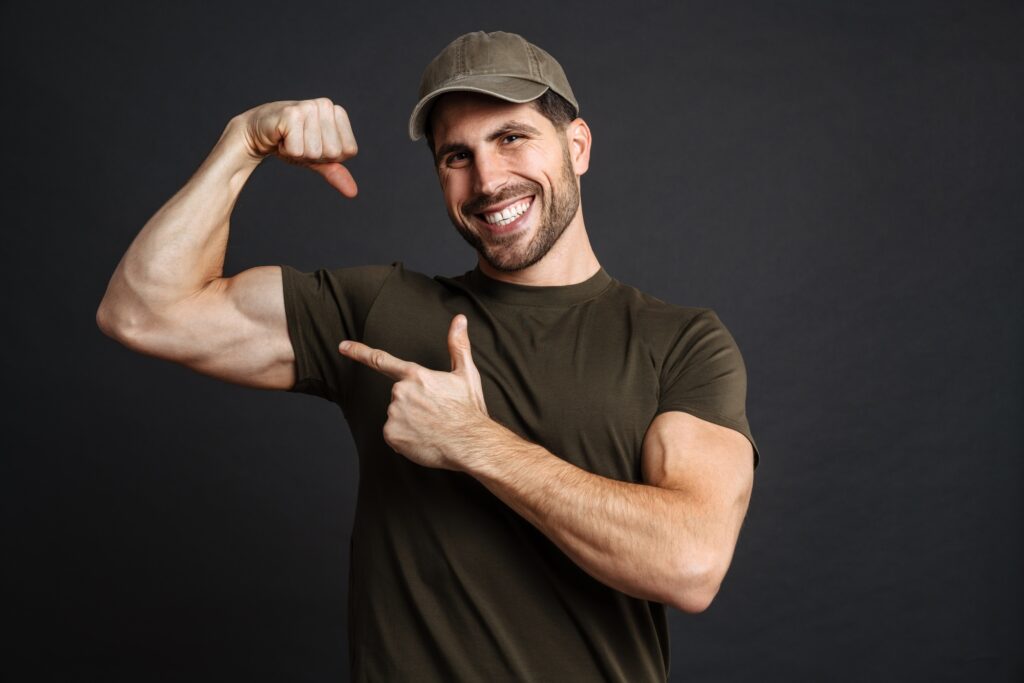 Strong healthy military man showing biceps isolated