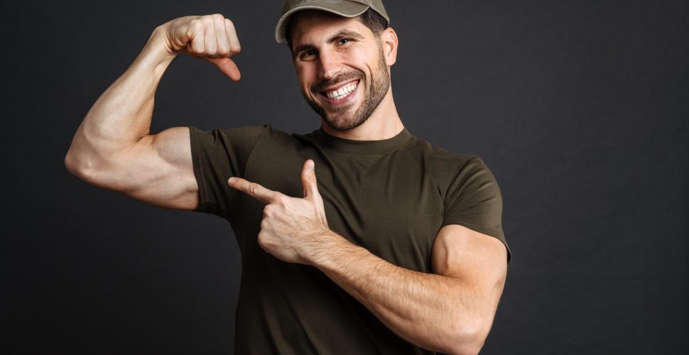 Strong healthy military man showing biceps isolated